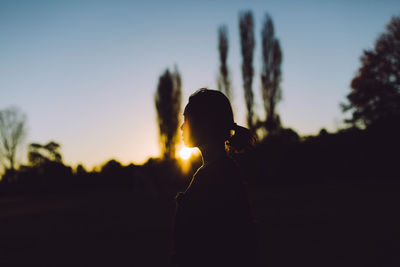 Silhouette woman standing against sky during sunset