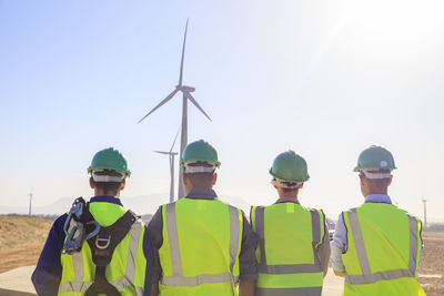 Rear view of four engineers on a wind farm