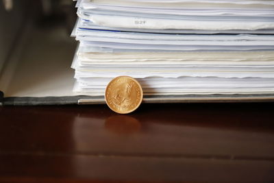 Close-up of coin by file on table