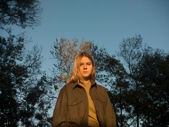 Portrait of a smiling woman standing against trees