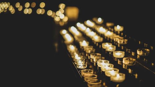 Tea light candles burning on votive stand in church