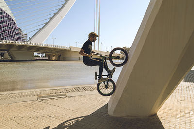 Man riding bmx cycle on footpath in city