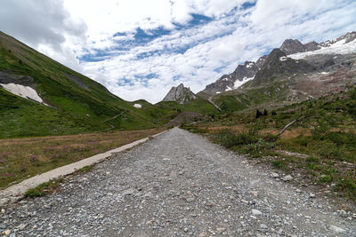 Road leading towards mountains against sky