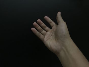 Close-up of human hand against black background