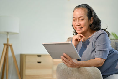 Portrait of young woman using laptop while sitting at home