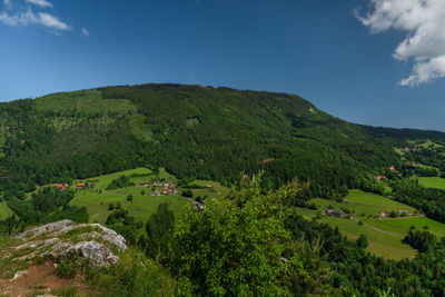 Scenic view of green landscape and mountains against sky