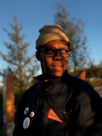 Portrait of man wearing hat standing against trees