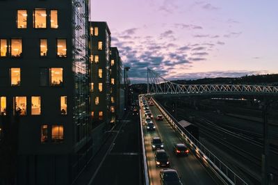 Cars on road in illuminated city against sky at night