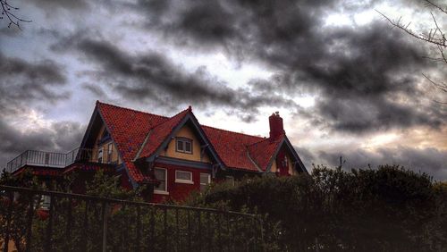 Low angle view of house against cloudy sky