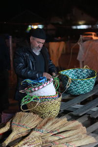 Man removing baskets while standing by table