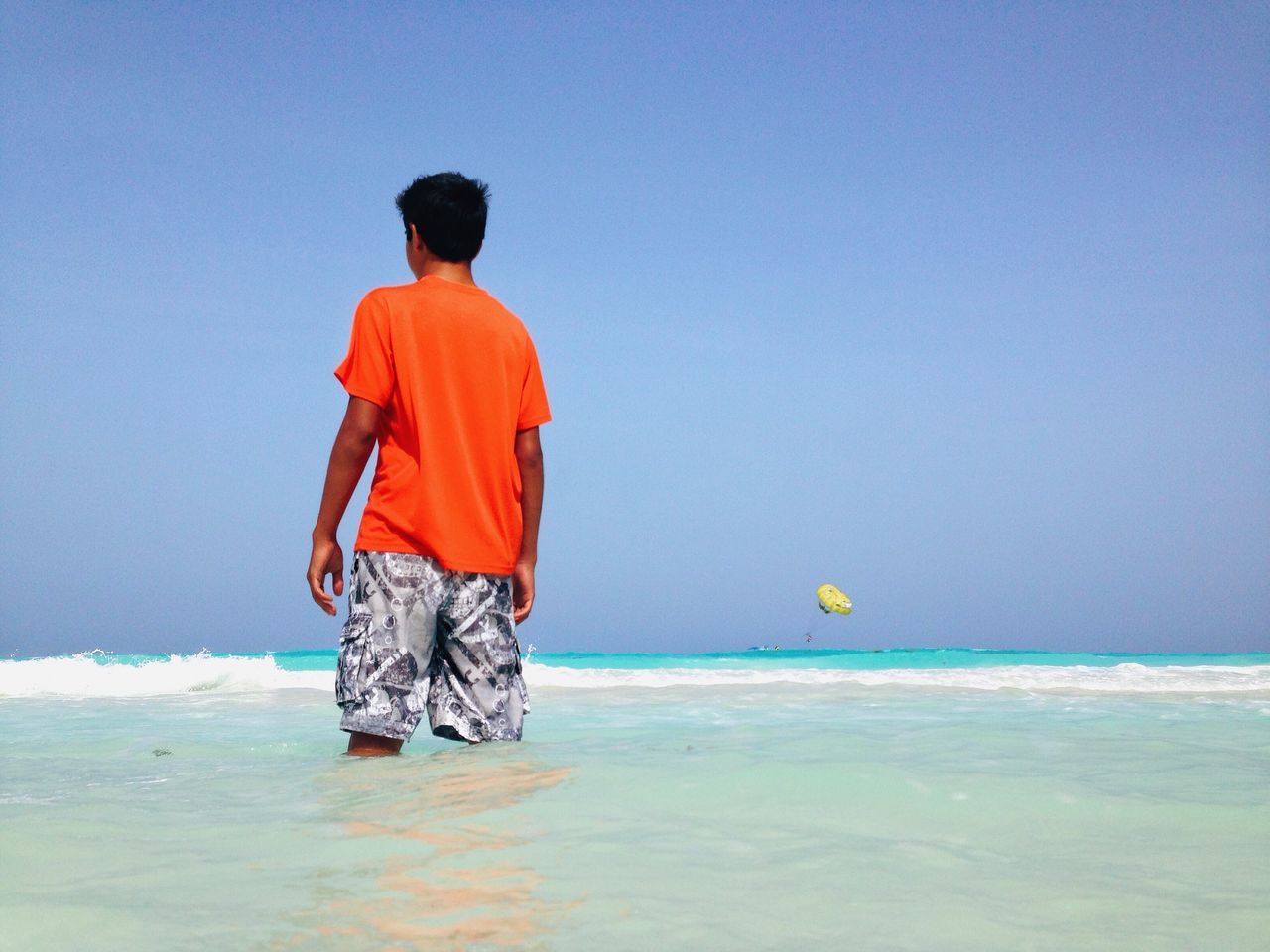 sea, water, clear sky, leisure activity, lifestyles, horizon over water, copy space, beach, rear view, full length, men, standing, blue, shore, tranquil scene, tranquility, scenics, vacations