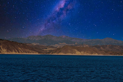 Scenic view of lake against sky at night