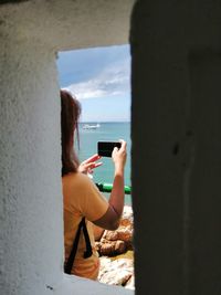 Woman photographing through mobile phone