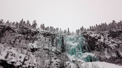 Panoramic view of snow covered land against sky