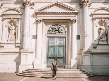 Full length of woman standing at entrance of historic building