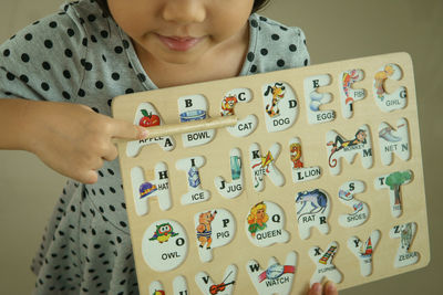 Midsection of girl holding alphabet slate