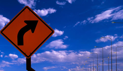 Road sign against blue sky