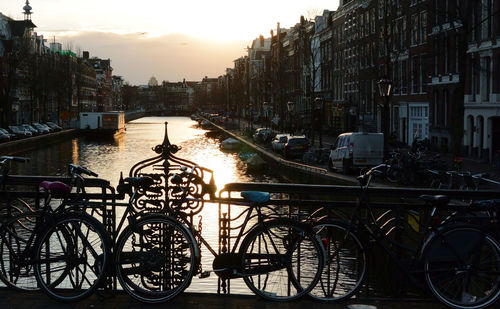 Bicycles in city against sky during sunset