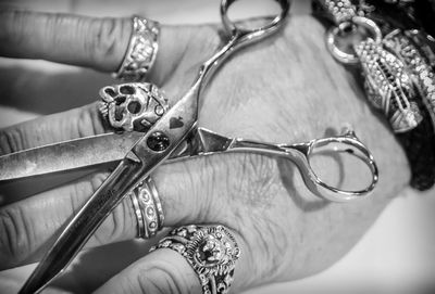 Cropped hand of barber with scissors in salon