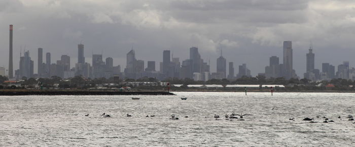 View of buildings in city against cloudy sky