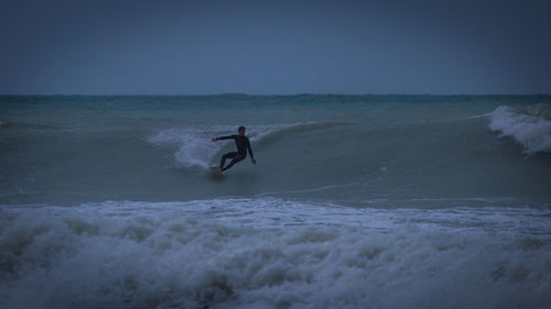 Man surfing on sea against sky