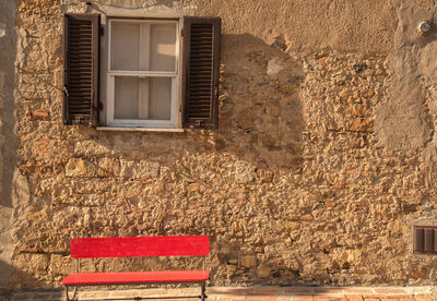 Empty red bench against wall