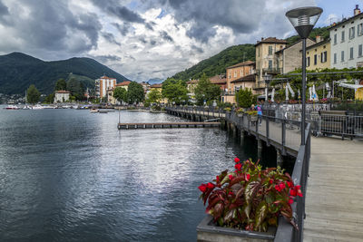 View of townscape by river against cloudy sky