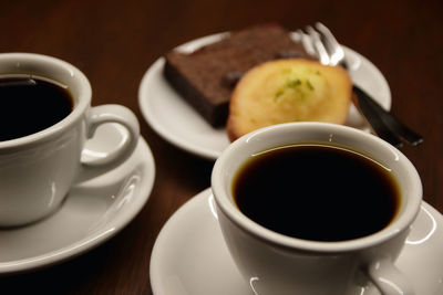 Close-up of coffee and cookie served on table