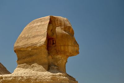 Low angle view of rock formation against clear blue sky