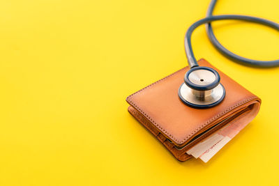 Close-up of electric lamp against yellow background