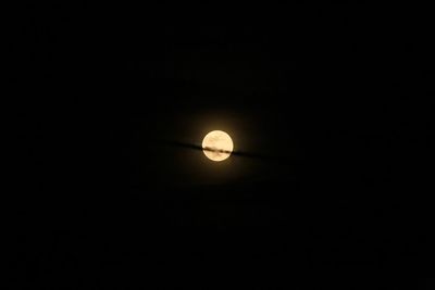 Low angle view of illuminated moon against sky at night