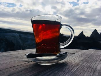 Cup of tea on table against sky