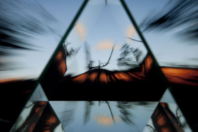 Close-up of reflection on mirror against sky during sunset