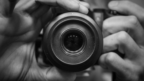 Close-up of man photographing by using camera