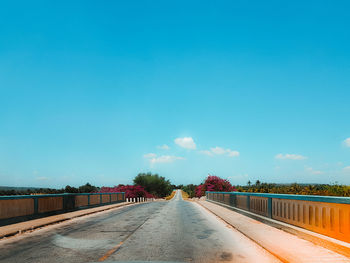 Empty road against clear blue sky