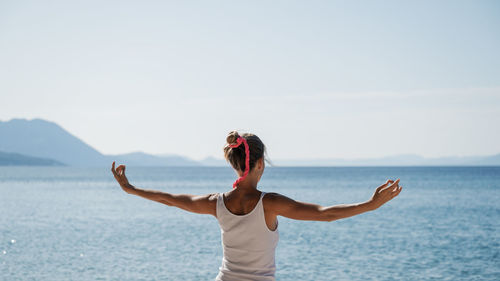 Full length of woman standing by sea against sky