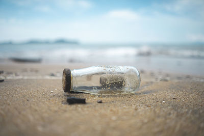 Close-up of sunglasses on beach against sky