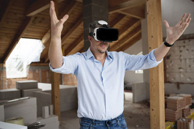 Midsection of man with arms raised standing at home