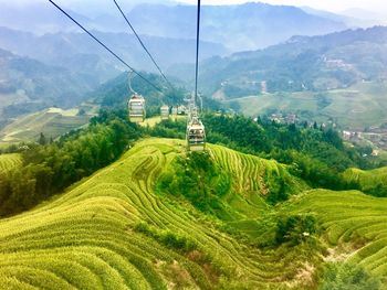 Overhead cable car over landscape against mountains