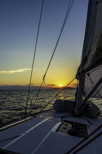 Sailboat in sea against sky during sunset
