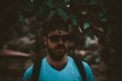 Green leaves against young man