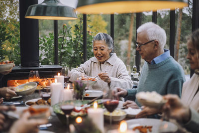 Senior woman serving food to male friend at dinner party