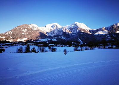 Scenic view of snowcapped mountains against clear blue sky