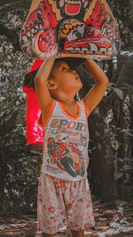 Portrait of girl standing against trees