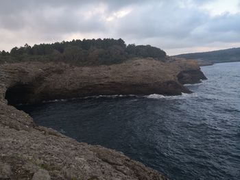 Scenic view of rocks on sea against sky