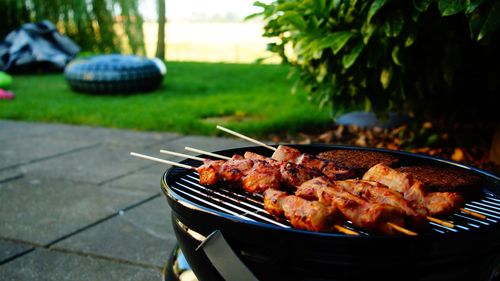 Close-up of meat on barbecue grill in yard