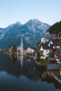 View of buildings by lake against mountain