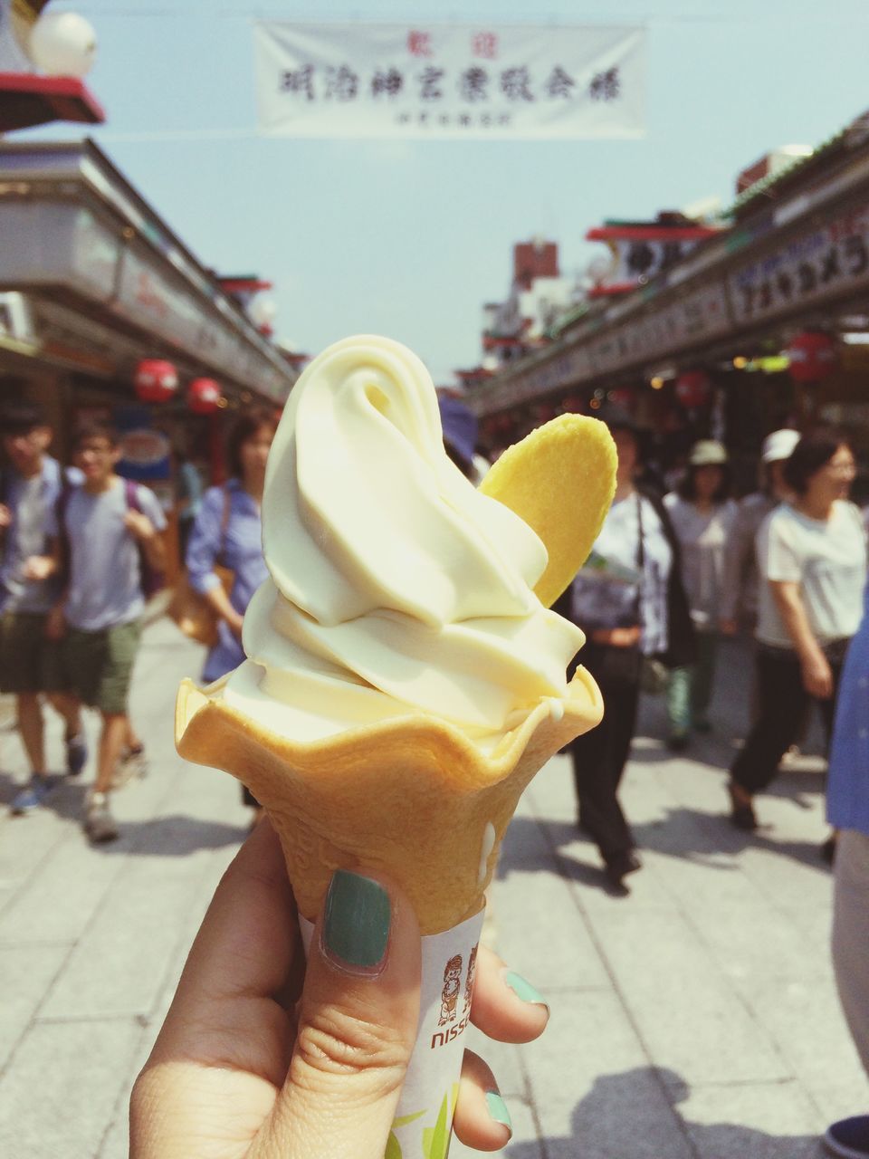 person, holding, focus on foreground, lifestyles, freshness, ice cream, part of, food and drink, cropped, frozen food, leisure activity, built structure, sweet food, architecture, incidental people, ice cream cone