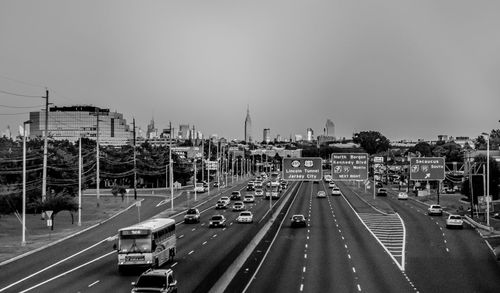 Cars on road in city against sky