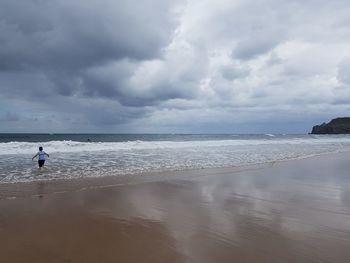 Boy on the beach. view of sea against sky